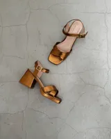Sandalias doradas de cuero vacuno con taco bloque de 8cm y tira al tobillo.