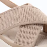 Sandalias de mujer color beige con plataforma blanca. Presentan tiras anchas cruzadas en la parte del empeine, confeccionadas en tejido de punto. Cuentan con tira ajustable con hebilla en el talón.