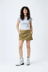 Remera color beige de punto acanalado con silueta relajada y manga corta raglán. El ruedo tiene terminación ondulada. El tejido con elasticidad ligera brinda comodidad y movimiento.