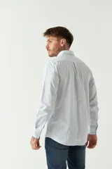 Camisa celeste a rayas rojas de hombre, manga larga, con bolsillo y logo bordado.