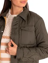 Campera color rosa pálido con diseño acolchado en forma de hojas, cuello camisero, cierre frontal con botones a presión, dos bolsillos de parche en el pecho y corte recto.
