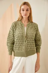 Campera bomber tejida en punto calado, con cierre de resina y diseño de mangas largas.