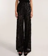 Pantalón pantalona de fiesta con cintura elástica y forro de short. Confeccionado en lentejuelas metalizadas con diseño geométrico.