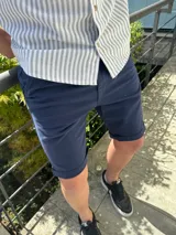 Bermuda de gabardina azul marino con ruedo doblado.