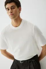 Remera blanca de algodón con tejido de punto calado, cuello redondo y corte estándar.