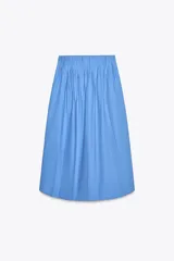 Falda midi celeste de popelín de algodón, tiro alto, cintura con pliegues, corte evasé y cierre con cremallera oculta en la costura.