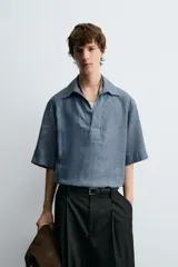 Camisa azul de lino con cuello polo, corte holgado y mangas cortas.