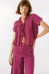 Camisa celeste de lino con cuello clásico, mangas cortas, corte crop y lazos en el frente.