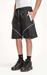 Bermuda negra de textil liviano con calce oversize, cintura elástica con cordón de ajuste y recortes decorativos en blanco. Presenta detalles reflectantes en los bolsillos delanteros y ribetes curvos blancos en la parte inferior.