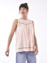 Blusa color durazno sin mangas, con cuello redondo y detalle de calado en la parte superior y en el ruedo.
