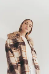 Tapado largo con estampado a cuadros en tonos marrón, beige y blanco. Presenta cuello con solapa y detalle de piel sintética.