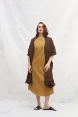 Chal marrón tejido en lana sin teñir, de textura gruesa y flecos en los extremos.