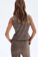 Chaleco entallado con estampado a cuadros, cuello redondo y cierre frontal con botones.