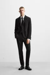 Blazer slim fit negra confeccionada en tejido con viscosa. Cuello con solapas de muesca, manga larga con puño con detalle de botones, bolsillo de vivo en pecho y de solapa en cadera, bolsillo interior, bajo con aberturas en espalda y cierre frontal con botones.