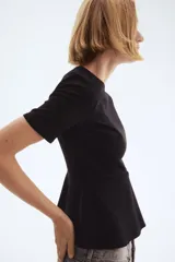 Top negro de manga corta con escote redondo y peplum acampanado en la parte inferior.