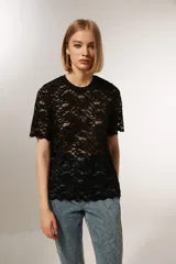 Top negro de encaje con mangas cortas, cuello redondo y corte holgado.