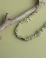 Collar regulable de bronce macizo con cuentas de piedra natural de cuarzo lima y jaspe rojo, y un dije central de labradorita.