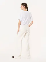 Pantalón de vestir blanco, de corte recto y amplio, confeccionado en jacquard. Se ajusta a la cintura con cierre, gancho pantalonero y botón interno.