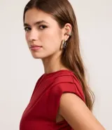 Blusa roja de viscosa con cuello redondo, sin mangas y pliegues en los hombros.