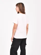 Remera de manga corta color rosa pálido con cuello redondo y un gran estampado frontal de los números "94" y una estrella en gris oscuro con efecto desgastado.