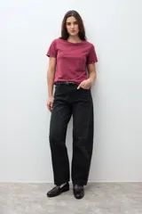 Remera de algodón color bordó, con cuello redondo, manga corta y detalle de ojalillos metálicos en el borde de las mangas.