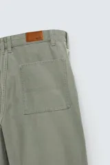 Pantalón de jean color verde con diseño de bloques de color en diferentes tonos de verde, corte amplio, tiro alto, cinco bolsillos y presilla para herramientas en la pierna.