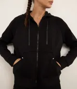 Campera deportiva negra con cierre frontal, capucha con cordón ajustable, bolsillos laterales y mangas largas.