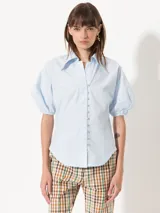 Camisa celeste de popelina, de silueta amplia y diseño liviano. Incluye cuello clásico y cierre frontal con botones.