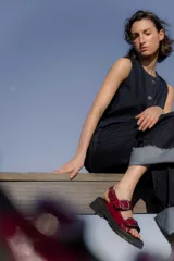 Sandalias rojas de cuero charol con hebillas plateadas y suela track.