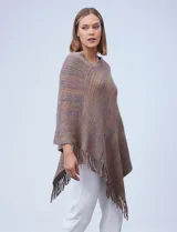 Poncho de tejido soft, color marrón jaspeado con toques de lila y rosado, con cuello redondo y terminación asimétrica con flecos.