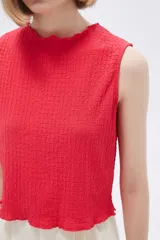 Musculosa negra con textura arrugada, cuello redondo y corte ajustado.