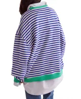 Remera de manga larga con cuello redondo y estampado a rayas horizontales amarillas y blancas, con puños y cuello en color celeste.