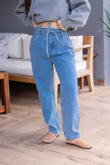Pantalón de jean celeste de corte babucha con lazo ajustable en la cintura.