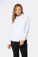 Blusa tipo camisa blanca con estampado de pequeñas flores negras, manga larga, botones nacarados ocultos con cartera y doble capa en el frente para evitar transparencias.