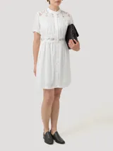 Vestido corto blanco de lino y viscosa, con cuello mao, mangas cortas, cierre frontal con botones, encaje en la parte superior y en la cintura, y forro a tono.