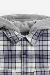 Sobrecamisa relaxed fit de algodón a cuadros azul marino y blanco, con capucha gris combinada a contraste, manga larga con puños abotonados, bolsillos plastrón en el pecho, bolsillos laterales en la cadera y cierre frontal con botones.