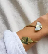 Brazalete rígido abierto, hecho a mano en bronce o alpaca, con terminaciones en forma de media luna y hojas.