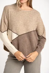 Sweater de tejido de punto con diseño de bloques de color en tonos beige, blanco roto y bordó. Presenta cuello redondo y mangas largas.
