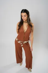 Mono largo color marrón con textura, escote halter, corte holgado, cinturón de cuero con estampado animal y cierre frontal con botones.