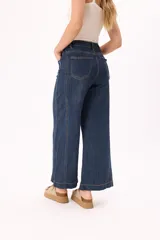 Pantalón jean azul oscuro, de corte ancho y tiro alto.