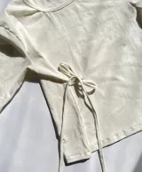 Remera blanca de manga larga con lazo en la cintura.
