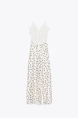 Vestido midi de satén color blanco con estampado de lunares negros, escote en pico, tirantes finos ajustables y espalda descubierta.
