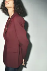 Blazer marrón de corte entallado, con cuello solapa, manga larga, bolsillos delanteros con solapa y cierre frontal con un botón.