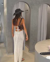 Vestido largo de tejido de punto color crema, con escote halter y aberturas laterales.