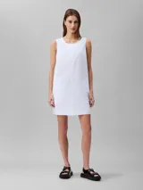 Vestido corto blanco de popelín de algodón, corte evasé y diseño sin mangas. Cuenta con cremallera en la parte trasera central, está parcialmente forrado y tiene bordado de Calvin Klein en la misma gama de tonos en el pecho.
