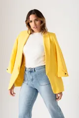 Blazer amarillo de corte entallado, con mangas tres cuartos con botón decorativo, solapas y bolsillos delanteros.