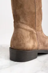 Bota de caña media color marrón de cuero gamuzado, con detalle de tira vertical en la parte superior de la caña.