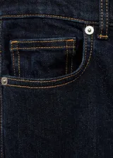Pantalón de jean azul oscuro, de corte flare y tiro alto, con cinco bolsillos y trabillas para cinturón.