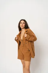 Blazer marrón claro a rayas verticales, con solapas de muesca, cierre con doble botonadura y corte holgado.