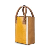 Matera combinada en símil cuero y croco color amarillo, marrón y blanco. Con división interior, asas cortas de mano y broche en asa.